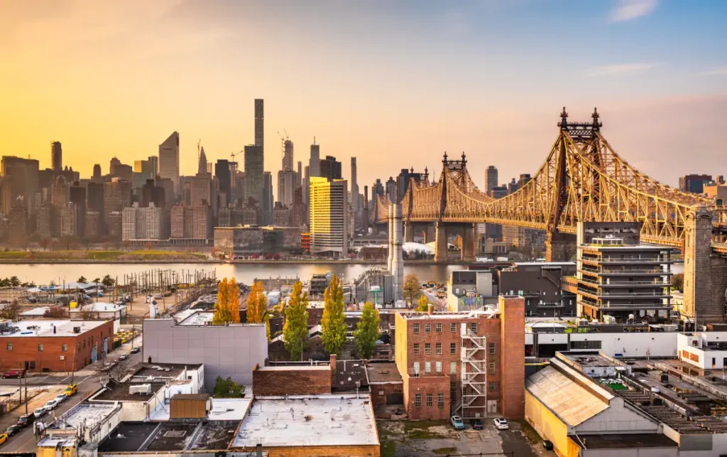 Manhattan Bridge silhouetted against the New York skyline at sunset, viewed from Queens, NYC