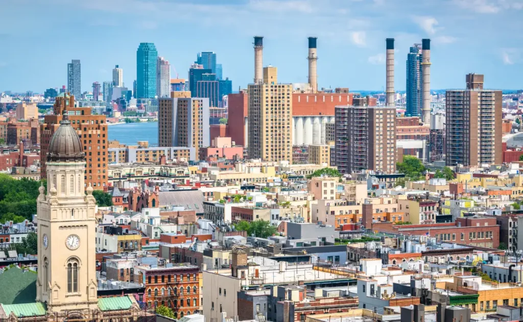 A panoramic view of the Bronx skyline, showcasing tall buildings against a clear blue sky from a high vantage point